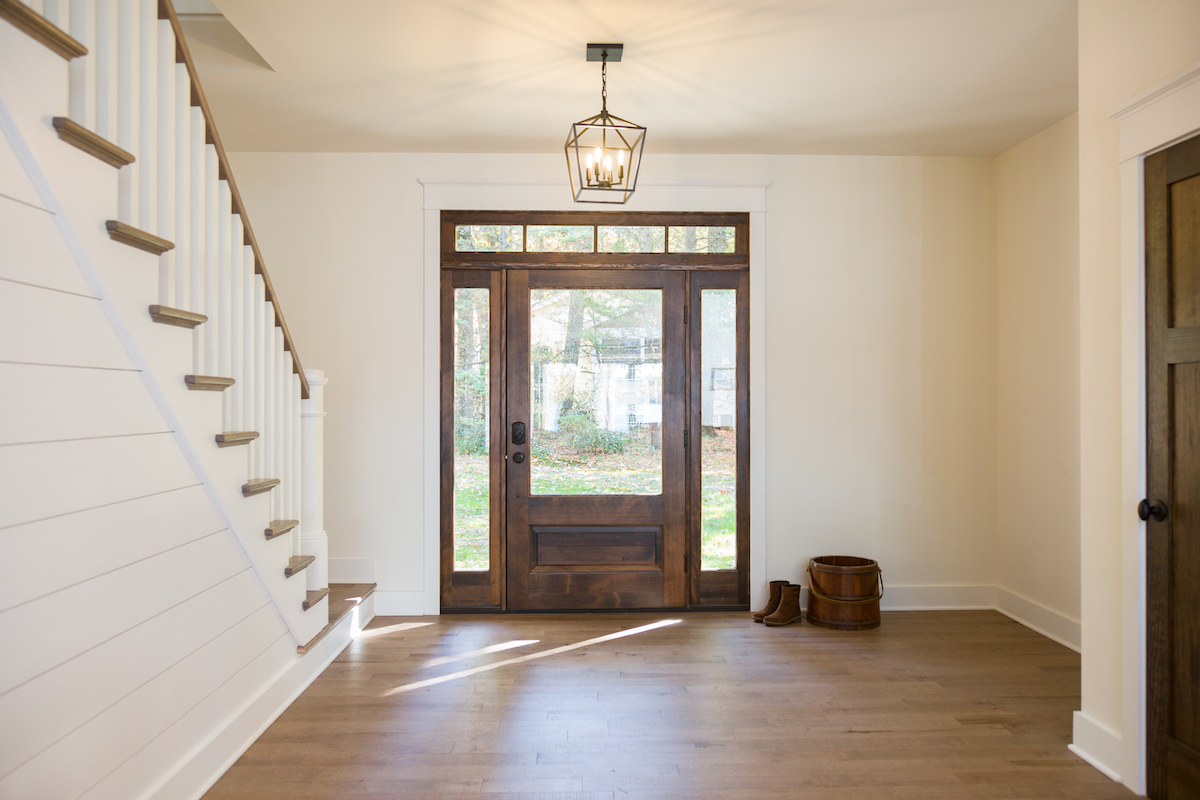 entryway-foyer-wide-wooden-door-white-staircase